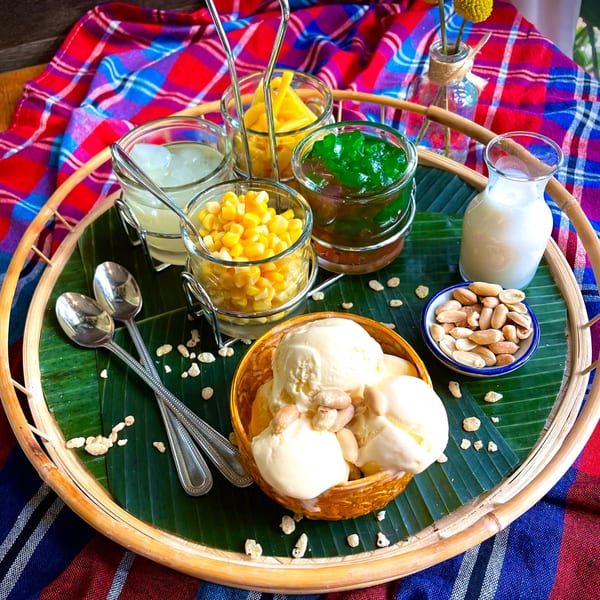 Thai dessert platter with ice cream, corn, jackfruit, green jelly, coconut milk, and peanuts.