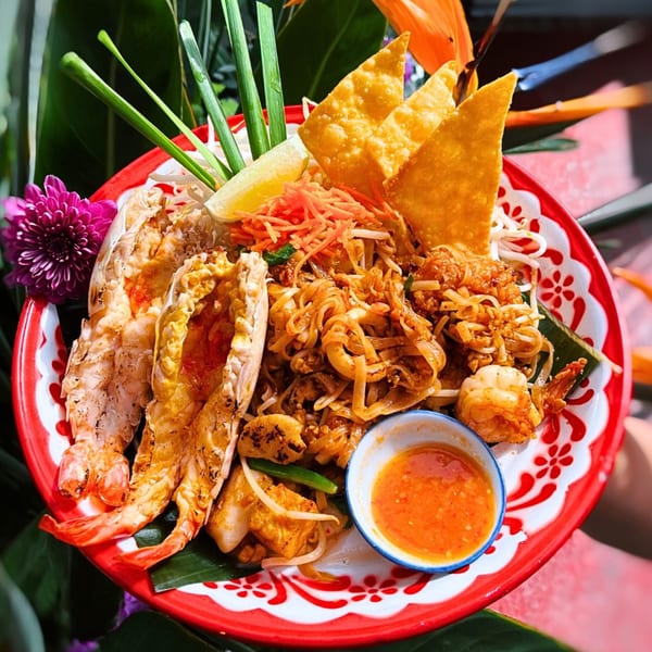 Daughter Thai Kitchen's Pad Thai with grilled prawns, crispy wontons, and a side of chili sauce.